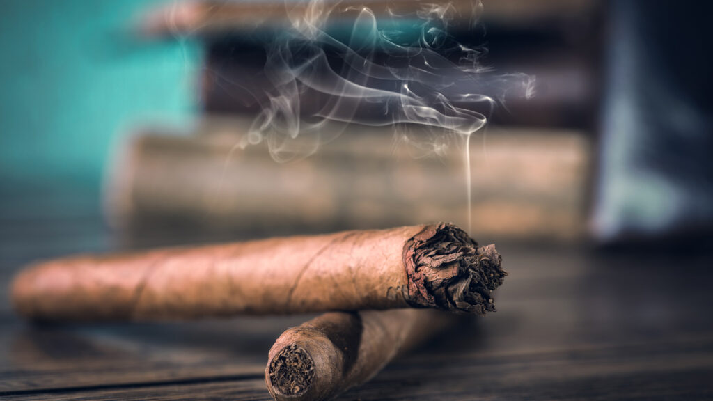 Image of smoldering cigars representing smoking and oral health