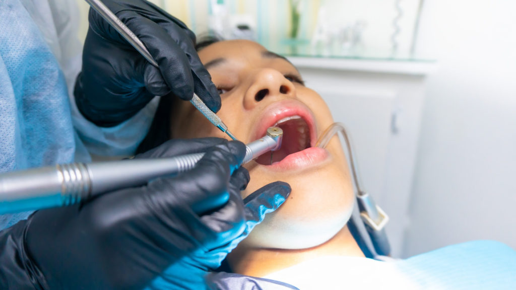 Image of girl getting tooth extraction and tooth extraction aftercare tips from her dentist.