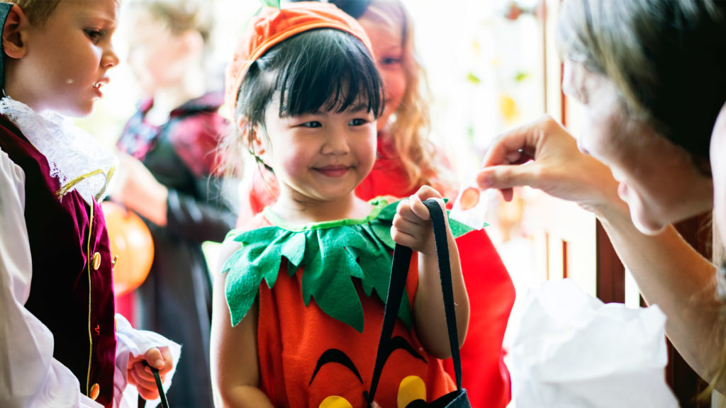 Halloween dental safety is on the mind of this young girl getting candy while trick or treating.